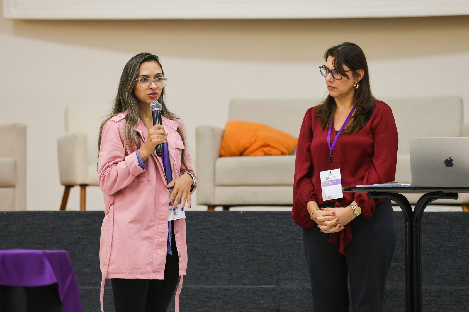 Aline Andolfo falando ao microfone durante uma palestra